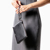 Femme tenant une petite pochette en cuir noir avec bandoulière Maison Marrain DeuxVie