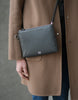Woman holding Maison Marrain DeuxVie small black leather pouch with shoulder crossbody  strap