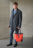 elegant Man with umbrella holding the DeuxMag All Weather big neoprene and leather mandarin and blue Tote bag 