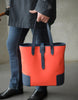 detail of elegant Man with umbrella holding the DeuxMag All Weather big neoprene and leather mandarin and blue Tote bag 