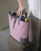 DeuxMag All Weather big neoprene and leather rose and grey Tote bag with wine bottle on top of a suitcase