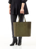 woman in high heels holding a Maison Marrain DeuxVin leather tote Bag in vine green