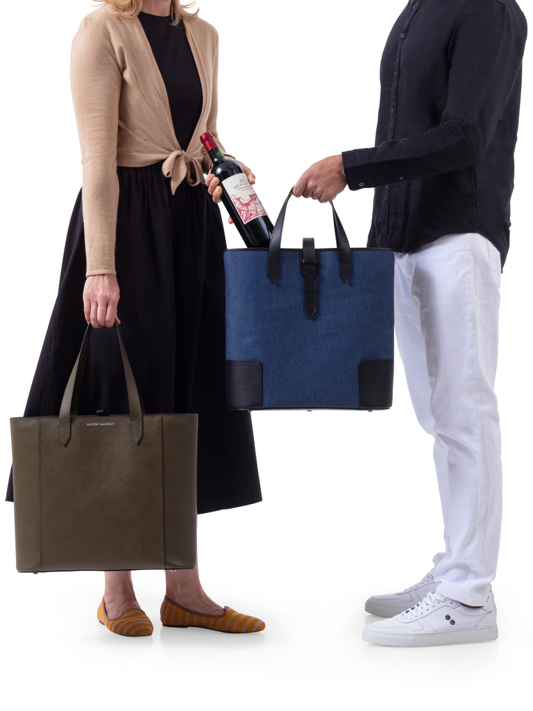 A couple holding the Deuxmag in black and blue and the Deuxvin in green tote bags