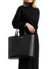 Woman in black holding Maison Marrain DeuxVin leather Bag in black 