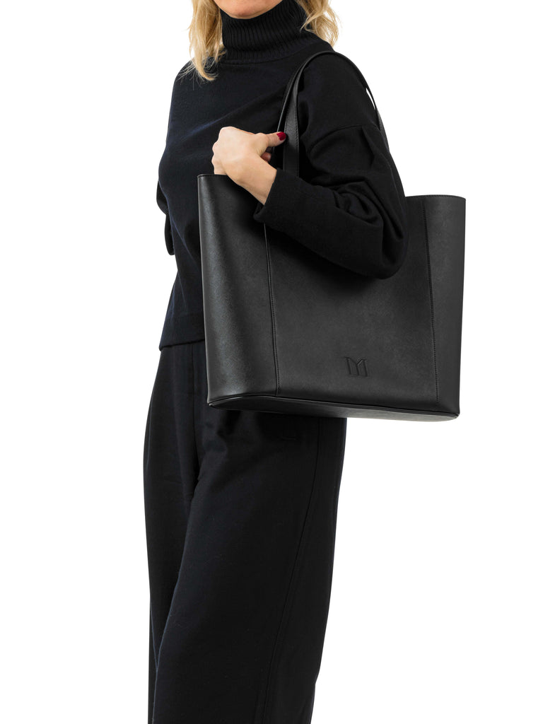 Woman in black holding  Maison Marrain DeuxVin leather Bag  in black 